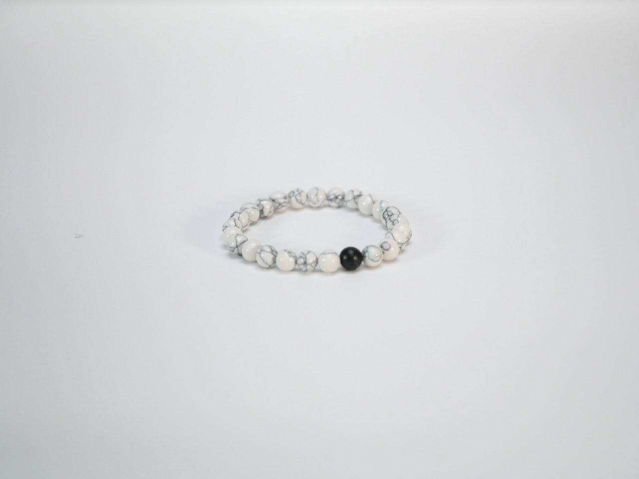 Black lava bead bracelet with white stone accents side view